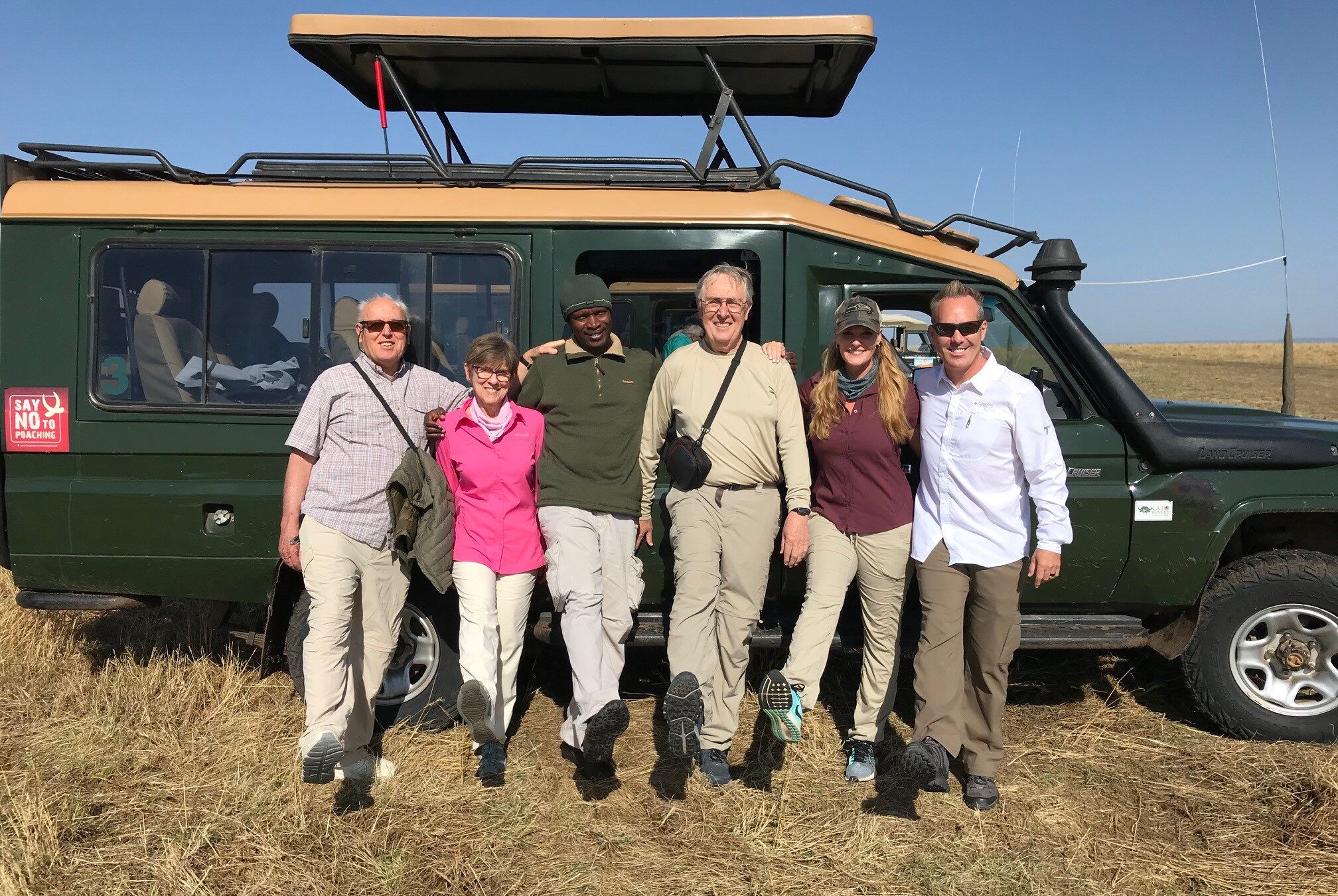 George Omuya and tour group with safari vehicle