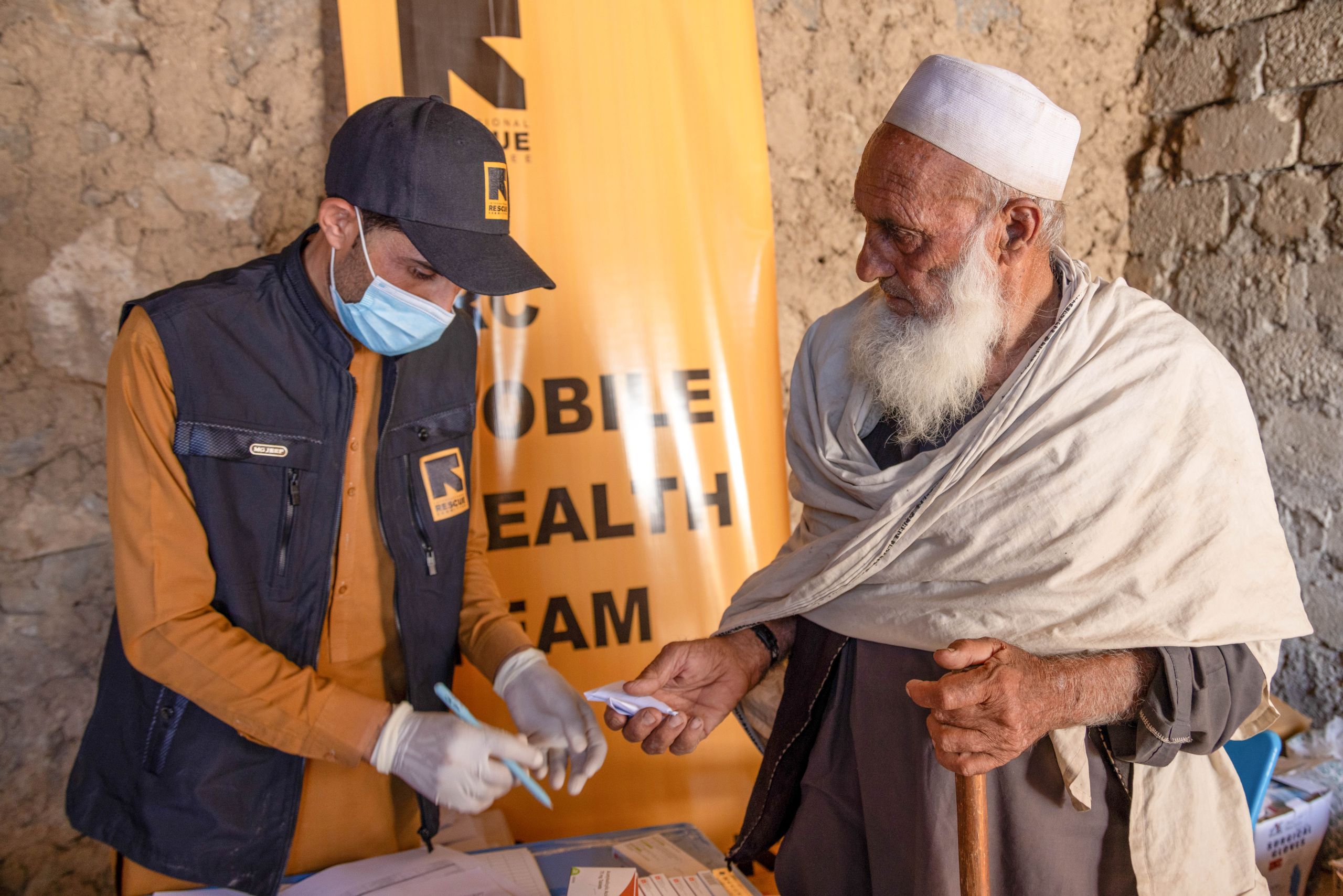 Afghanistan: Qader Mohammed (100 years old), a client from the affected community who got injured during the earthquake, getting medicine free of charge from the IRC clinic. © The International Rescue Committee Photo by Abdul Khaliq Sediqi for the IRC