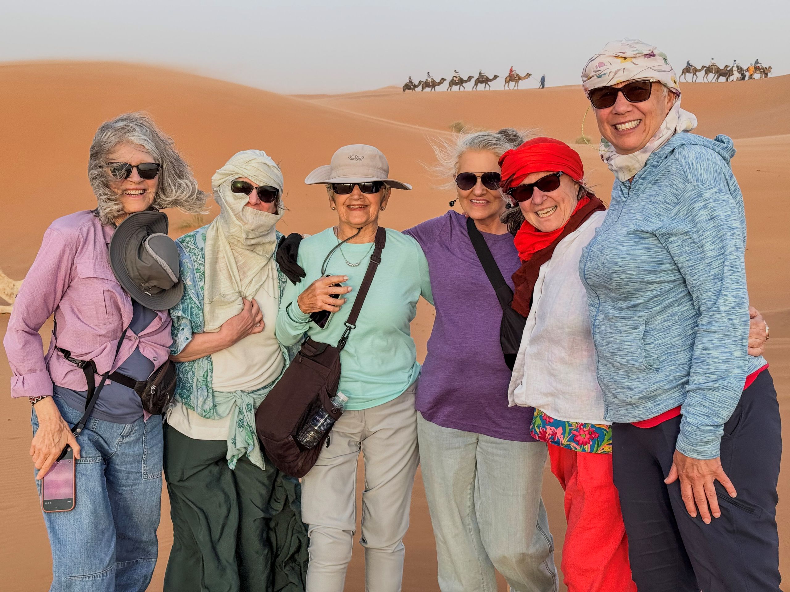 Odysseys guests smile amid the windswept sands of the Sahara. Photo: Gary Head